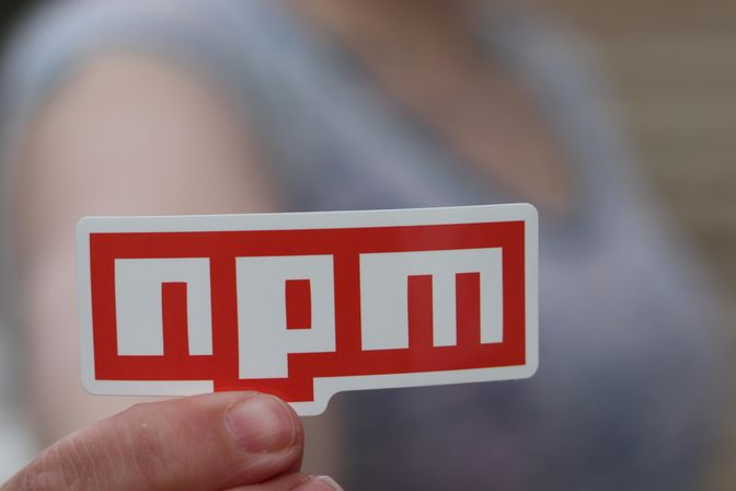 A man holding an npm sticker.