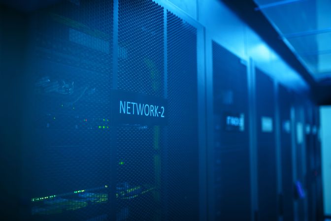 A darkened server room lined with network racks.